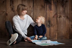 mom and young son sitting in front of a map and looking at each other