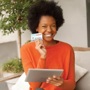 Woman in orange shirt holding an ipad and a credit card