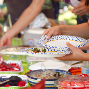 A table of food and someone holding a bowl.