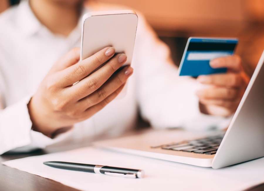 Woman holding credit card and phone