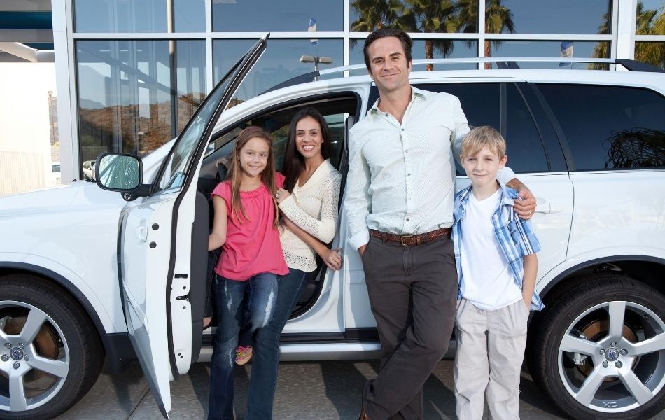 Family in front of a car