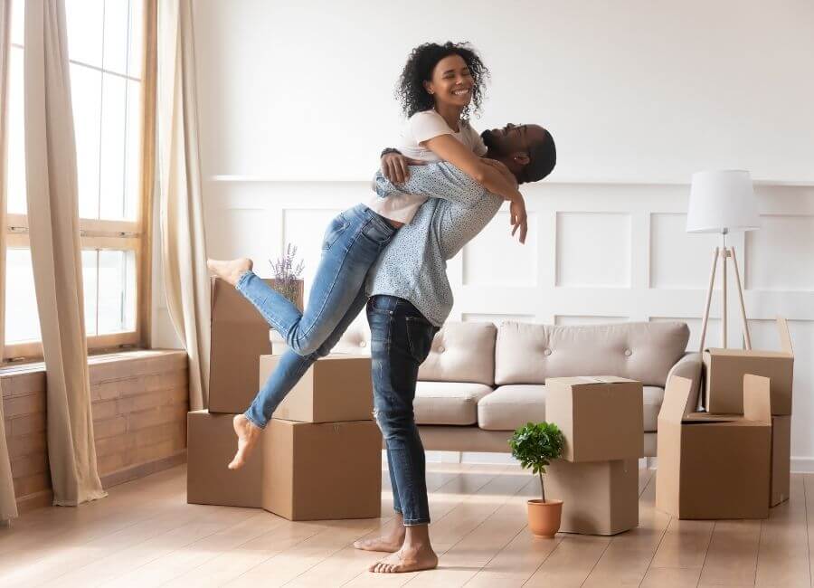 Man lifting woman in new home- first-time homebuyers