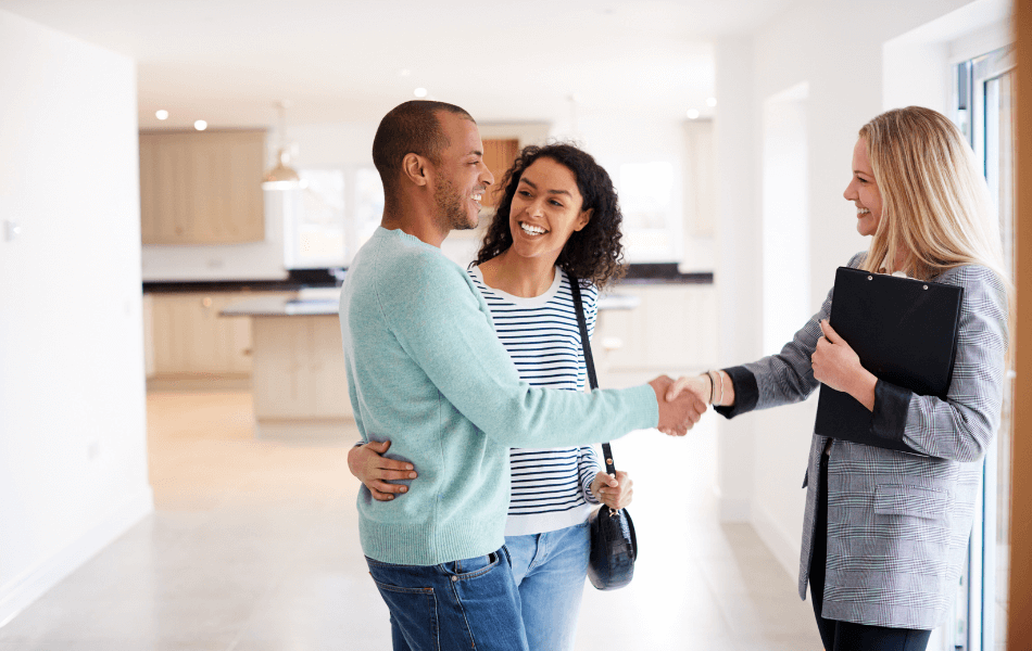 A couple shaking hands with a realtor