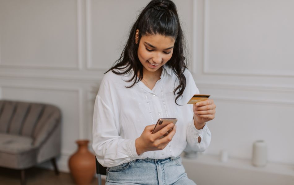 Woman paying for online purchase on phone with credit card