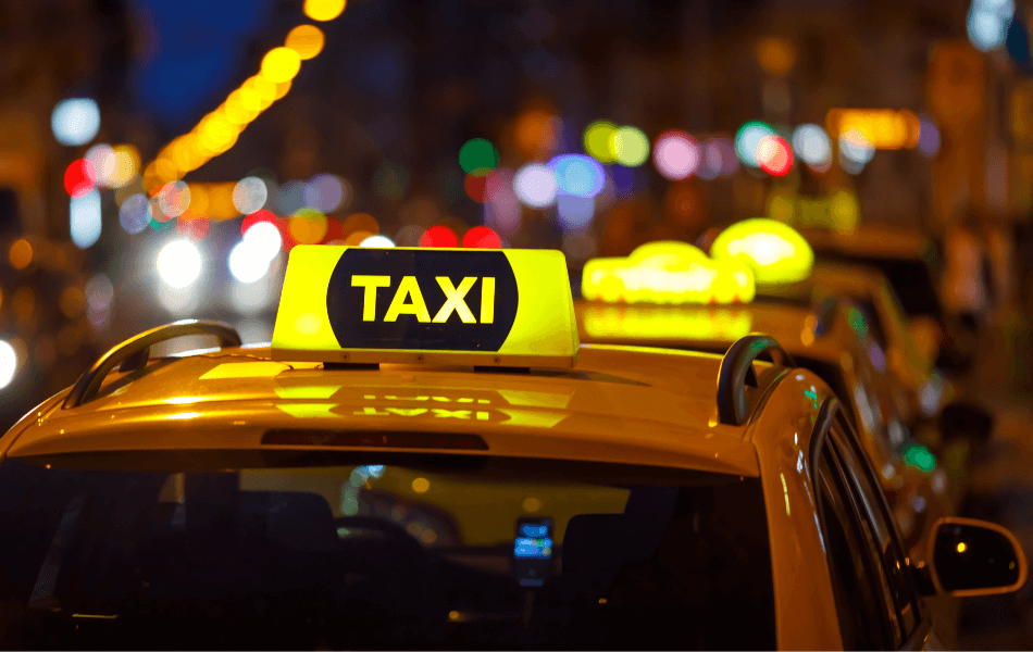 Lit up taxi sign on top of a car