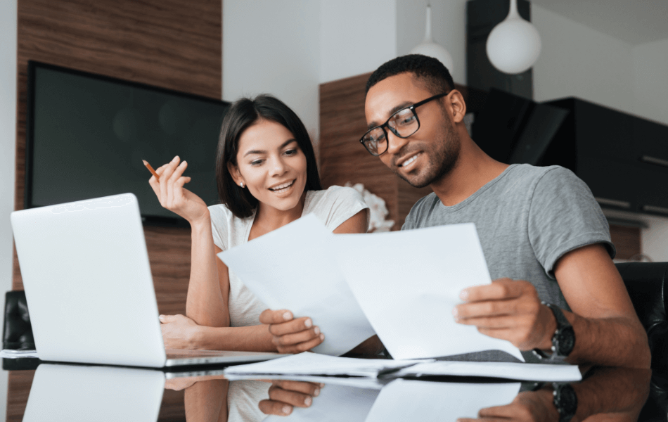 Couple looking over documents and laptop