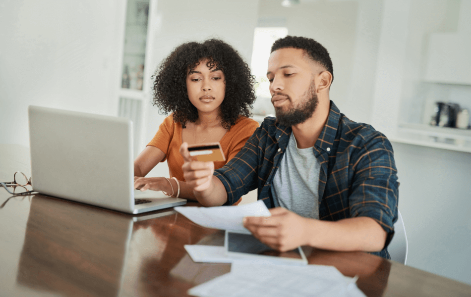 A couple is on a laptop and reviewing their credit card statement