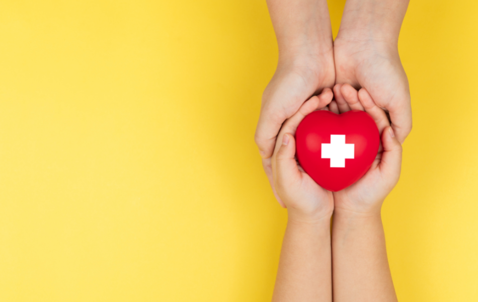 Hands holding a heart with a cross