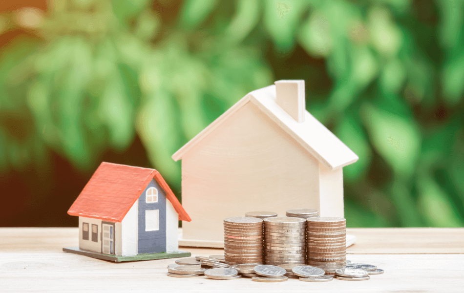 Two little houses next to a stack of coins