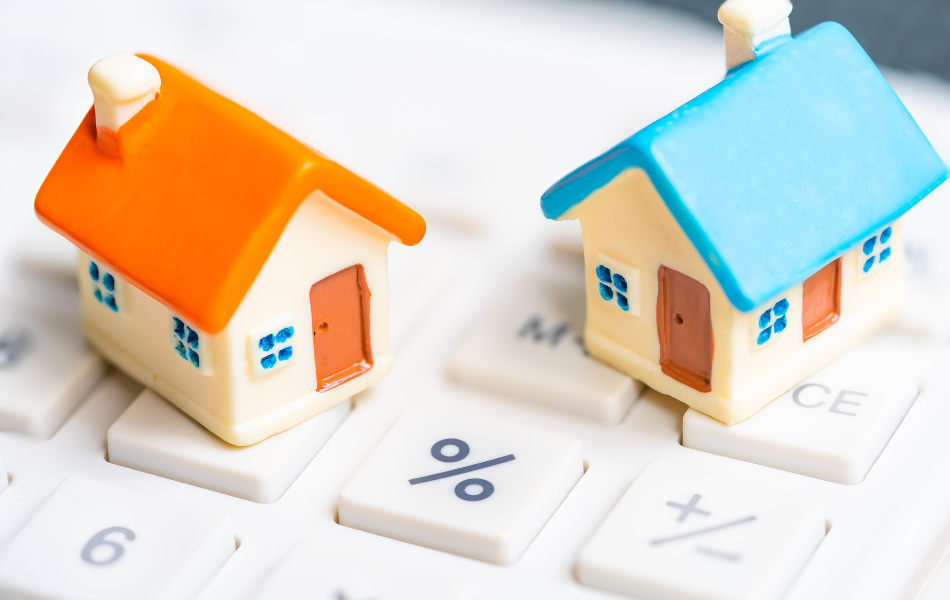 Little clay houses on top of a computer keyboard with a percentage sign in the middle