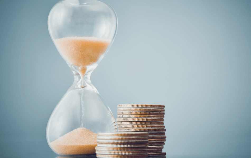 Hourglass with stack of coins next to it