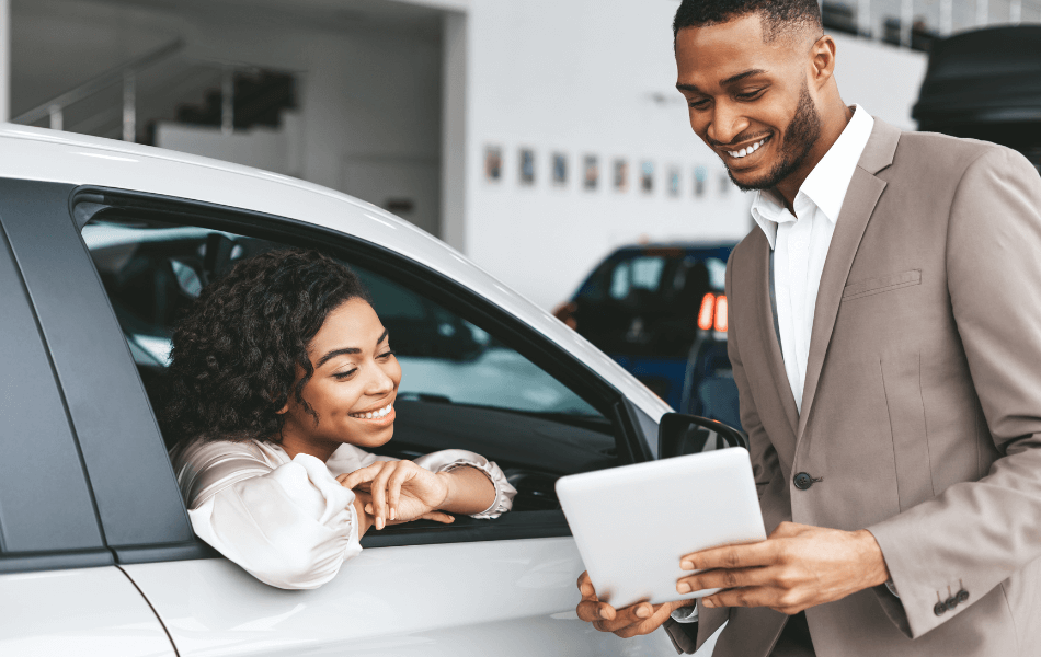 Two people at a car dealership