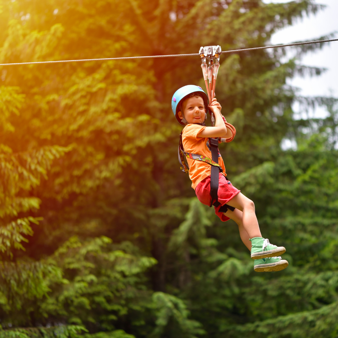 child ziplinning along tree line