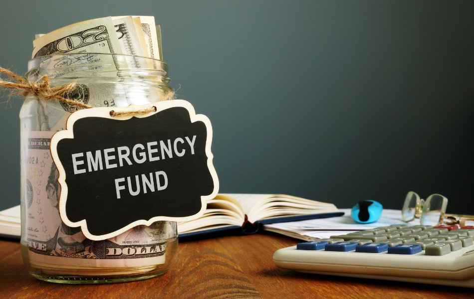Emergency Fund - Glass jar filled with money sitting on a desk labeled Emergency Fund