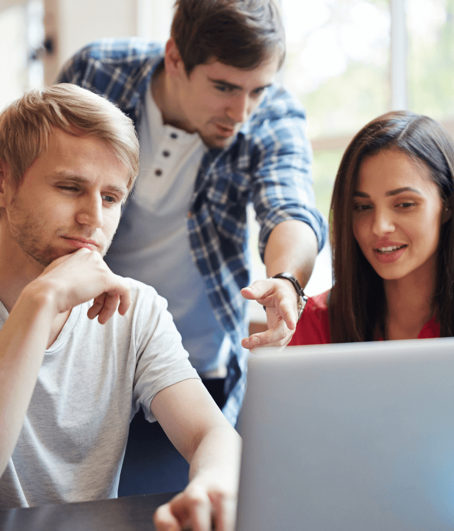 3 adults looking at a laptop
