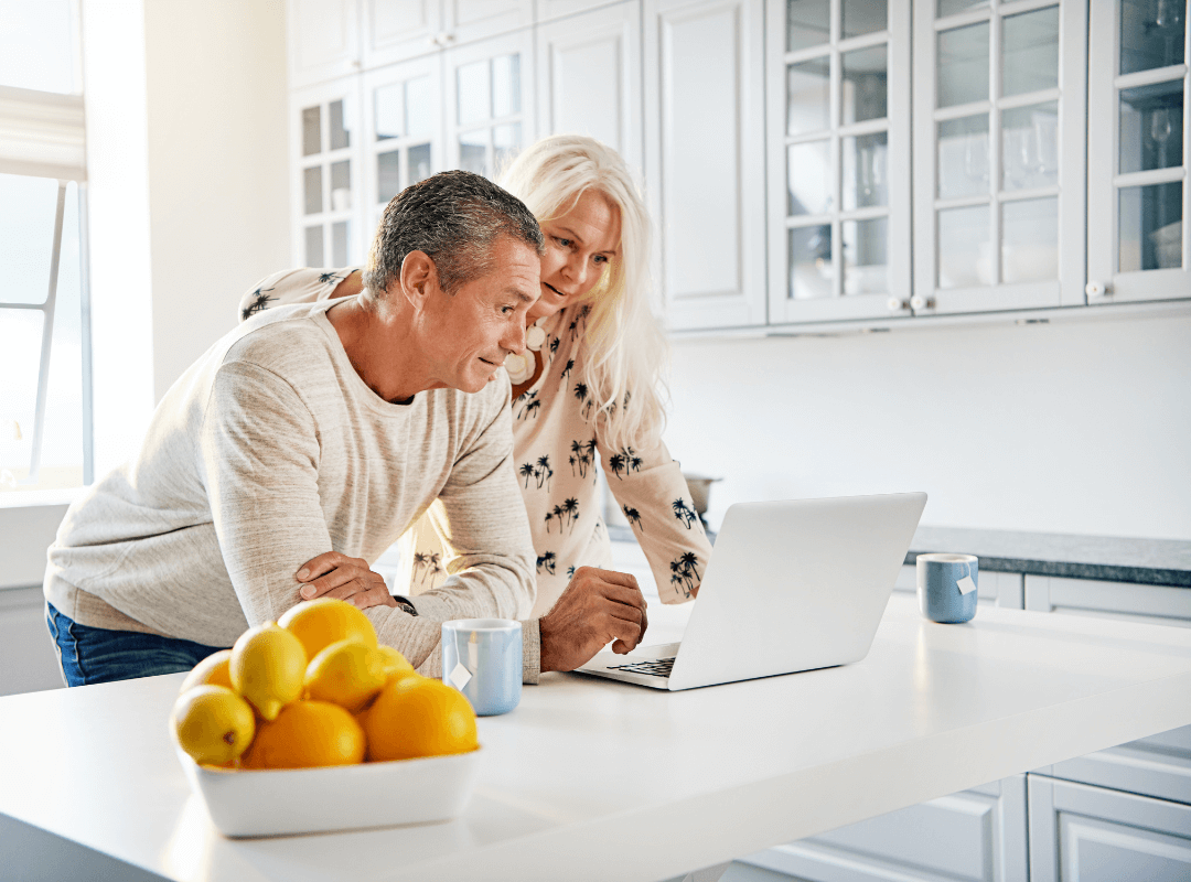 Couple looking at a computer in their kitchen