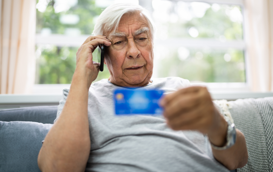 Don't Be a Victim to Scammers - Man Speaking on Phone While Holding Credit Card