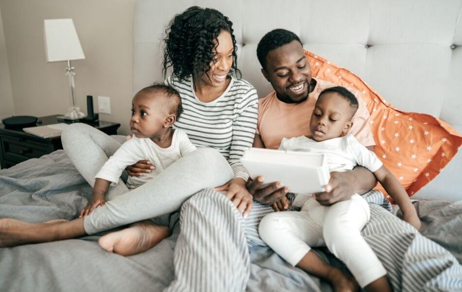 Family snuggling in bed