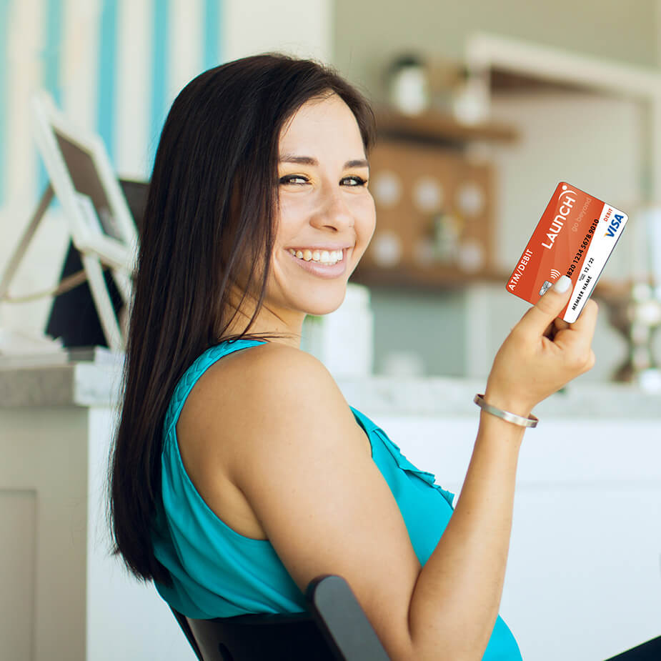 Woman smiling holding a Launch Debit Card